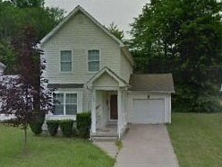 A small house with a brown door and a white garage door.