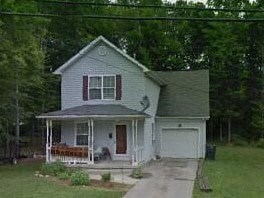 a white house with a porch and a driveway
