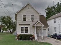 A house with a white front porch and a brown roof.