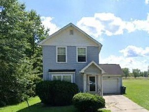 A two-story house with a garage and a driveway.