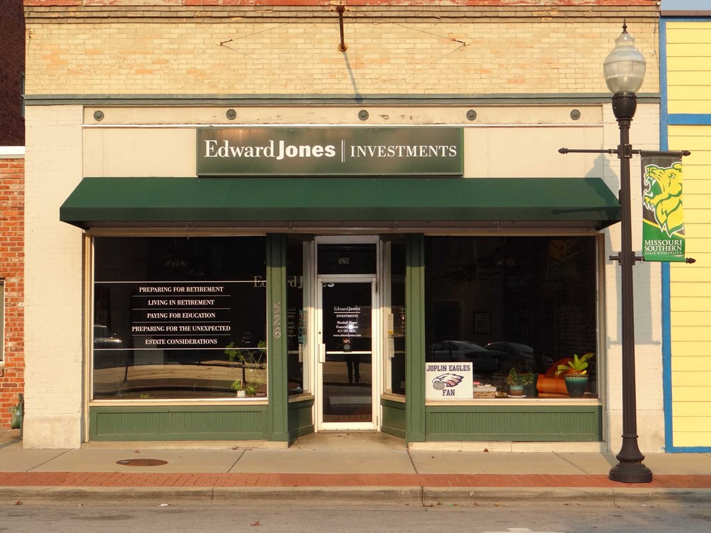 the front of a building with a green awning