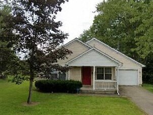 A small house with a red door and a porch.
