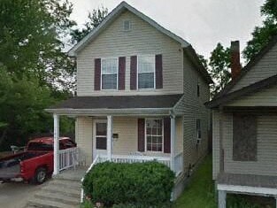 A house with a red truck parked in front.