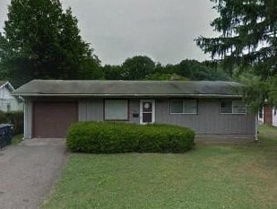 A house with a grey roof and a small front yard.