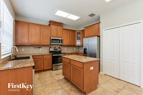 a large kitchen with wooden cabinets and stainless steel appliances