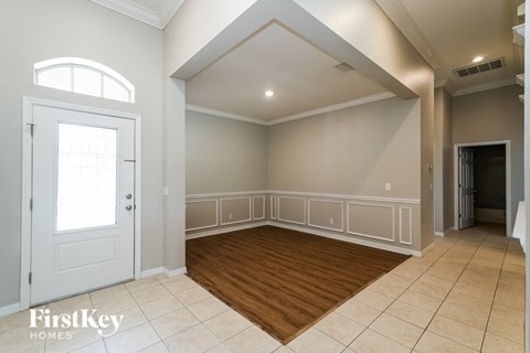 an empty room with a white door and a wooden floor