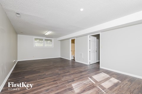 a living room with a hard wood floor and white walls