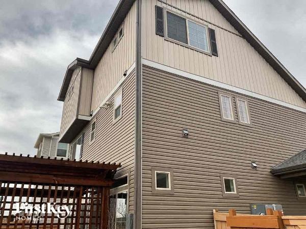 A house with a wooden exterior and a partially visible sign that says "Fasigky".