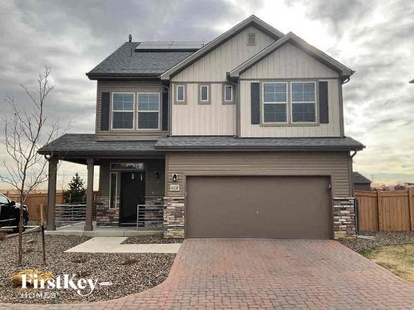 A house with a garage and a brick driveway is for sale.
