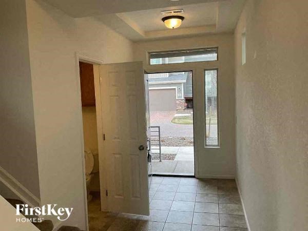 A hallway with a door leading to a backyard.