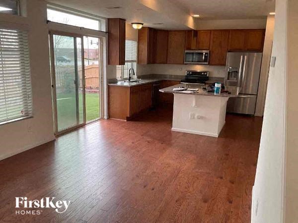 A kitchen with wooden floors and a white fridge.