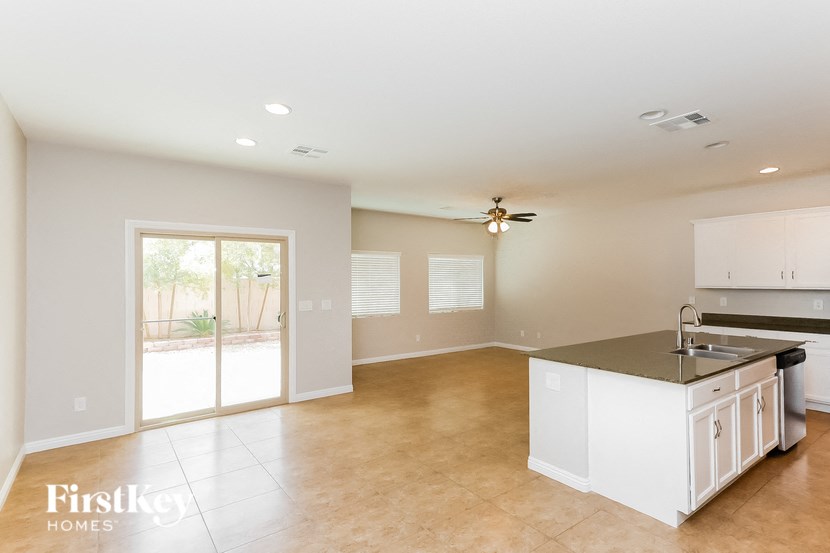 A spacious kitchen with a large island and a ceiling fan.
