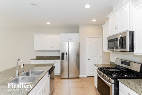 A kitchen with a stove top oven, sink, and refrigerator.