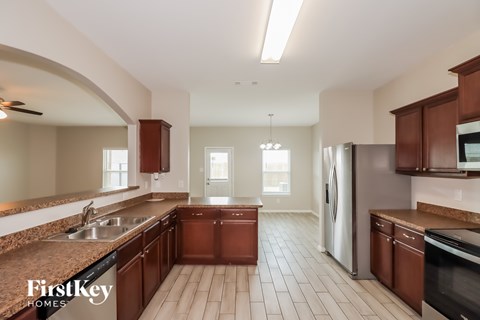 A kitchen with brown cabinets and a tile floor.