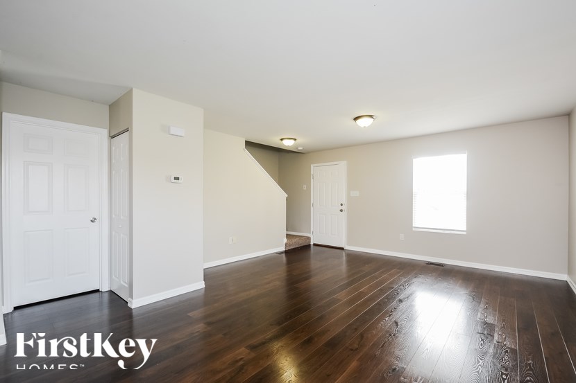 A spacious room with wooden floors and white walls.