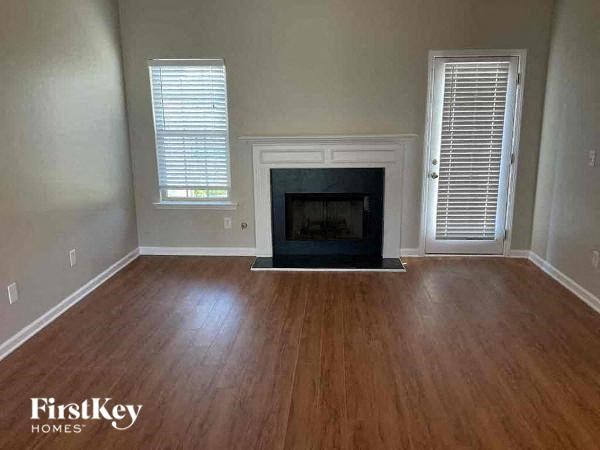 A room with a fireplace and wooden floors.