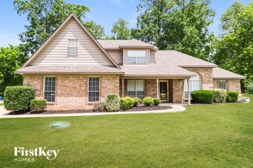 A house with a brick facade and a well-manicured lawn.