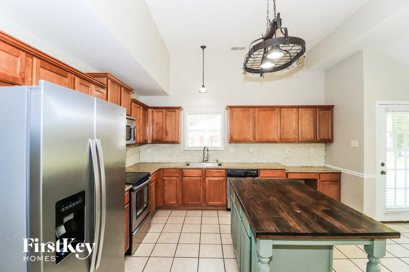 A kitchen with wooden cabinets and a stainless steel refrigerator.