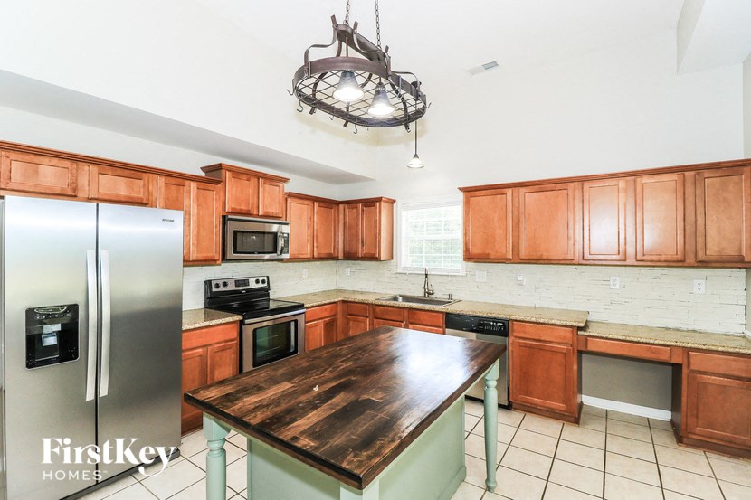A kitchen with wooden cabinets and a wooden island.