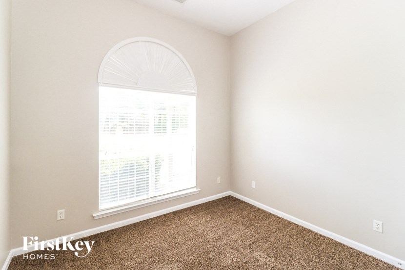 A room with a carpeted floor and a large window.