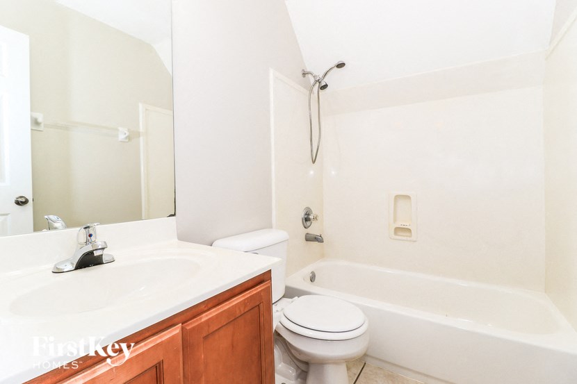 A white bathroom with a toilet, sink, and bathtub.