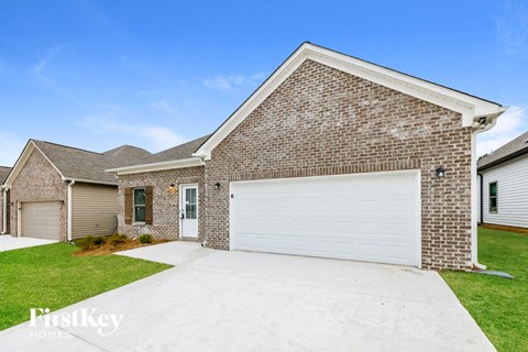 A brick house with a white garage door in front.