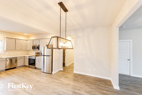 A kitchen with a refrigerator, oven, and microwave.