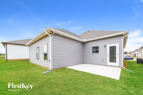 A single-story house with a grey exterior and a white door.