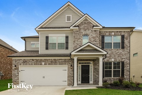 a tan brick house with a white garage door