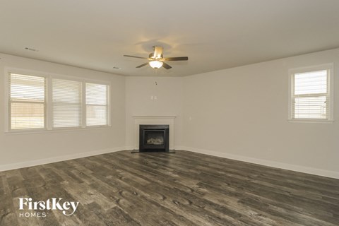 the living room with wood floors and a fireplace