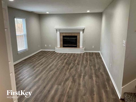 A room with a fireplace and wood flooring.