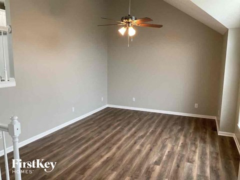 A room with wooden flooring and a ceiling fan.