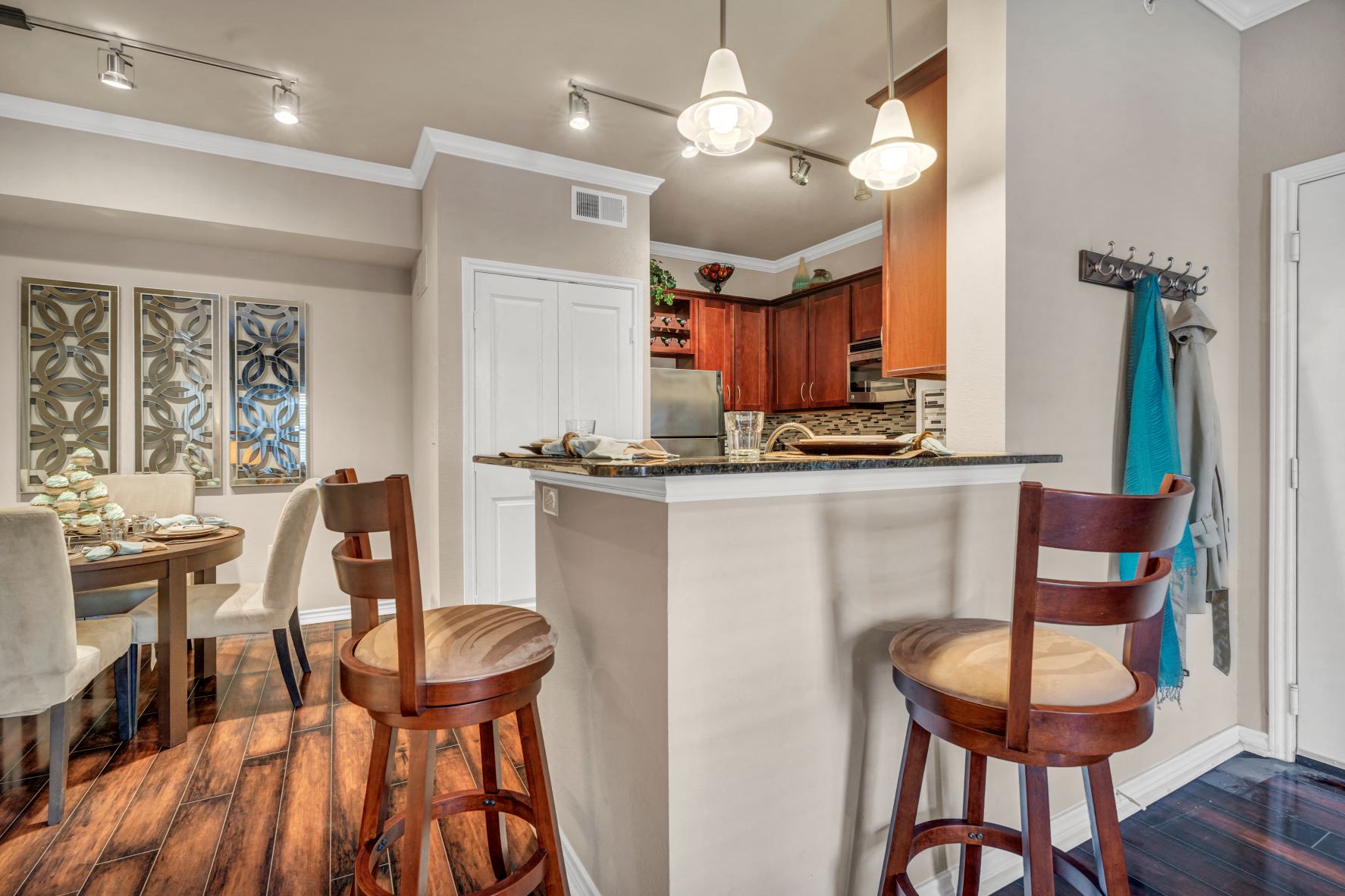 a kitchen and dining area with a bar and chairs