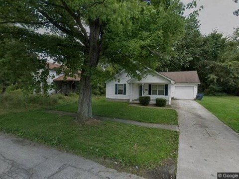 A white house with a tree in front of it.