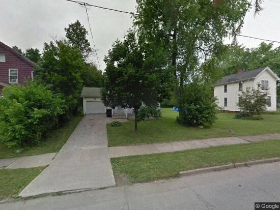 a street with a house and a sidewalk