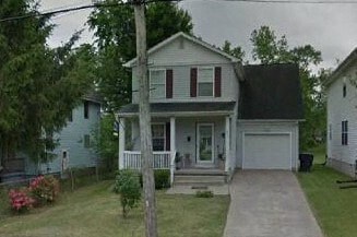 a white house with a porch and a sidewalk