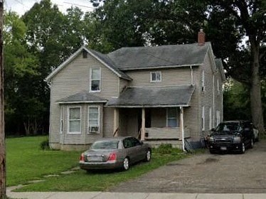 A house with a car parked in front of it.