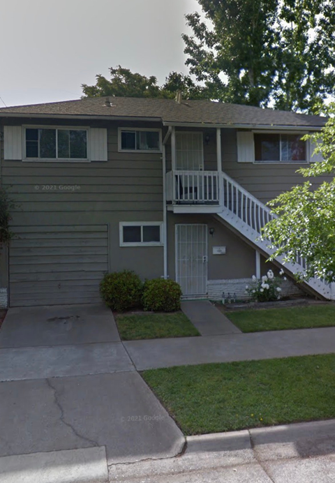 A two-story house with a garage and a balcony.