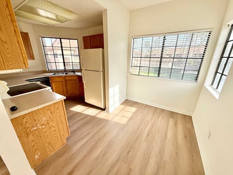 A kitchen with wooden cabinets and a white refrigerator.