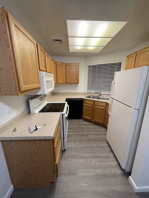 A kitchen with wooden cabinets and a white refrigerator.