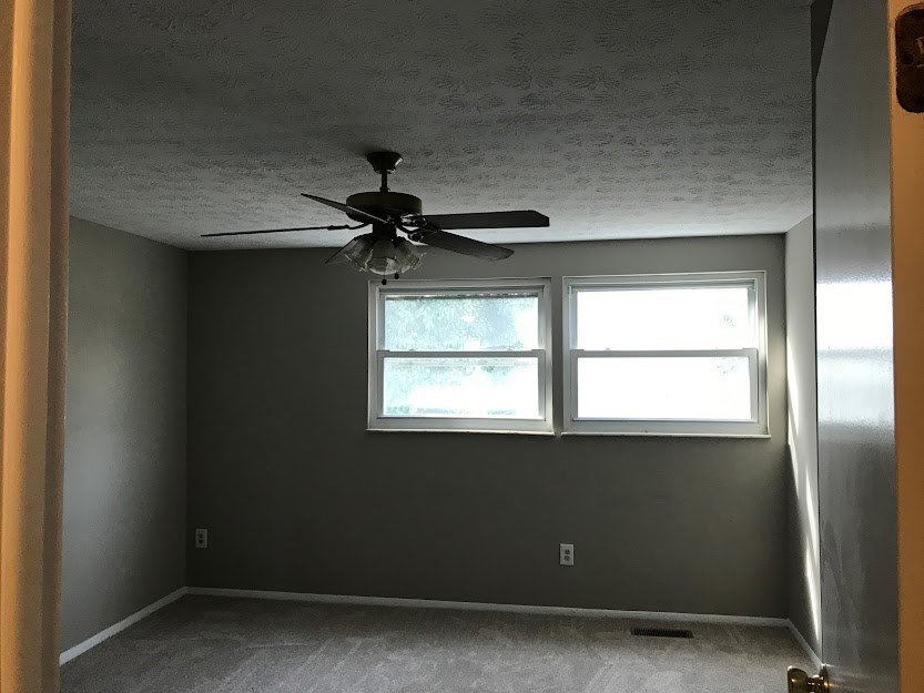 a room with a ceiling fan and a window