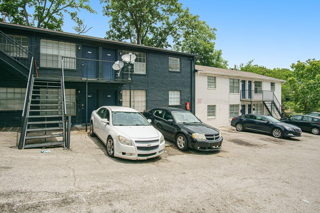 an apartment building with cars parked in front of it