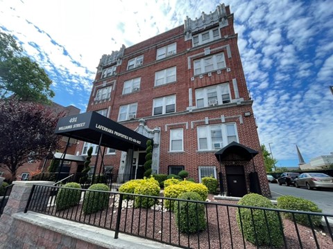 A tall red brick building with a black awning that reads "William Street Lafayette".