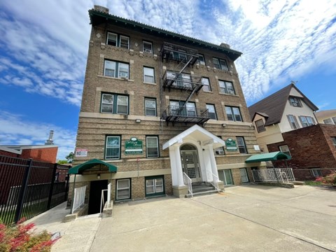 A building with a green awning and a sign that says "NO PARKING".