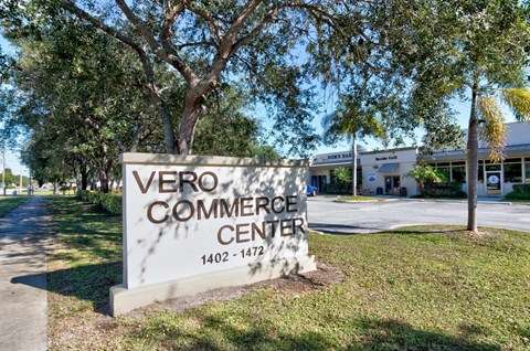 A sign for Vero Commerce Center stands in front of a building.
