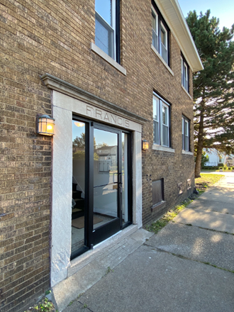 the front of a brick building with a glass door