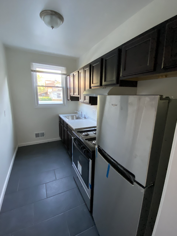 a kitchen with a refrigerator and a sink and a window