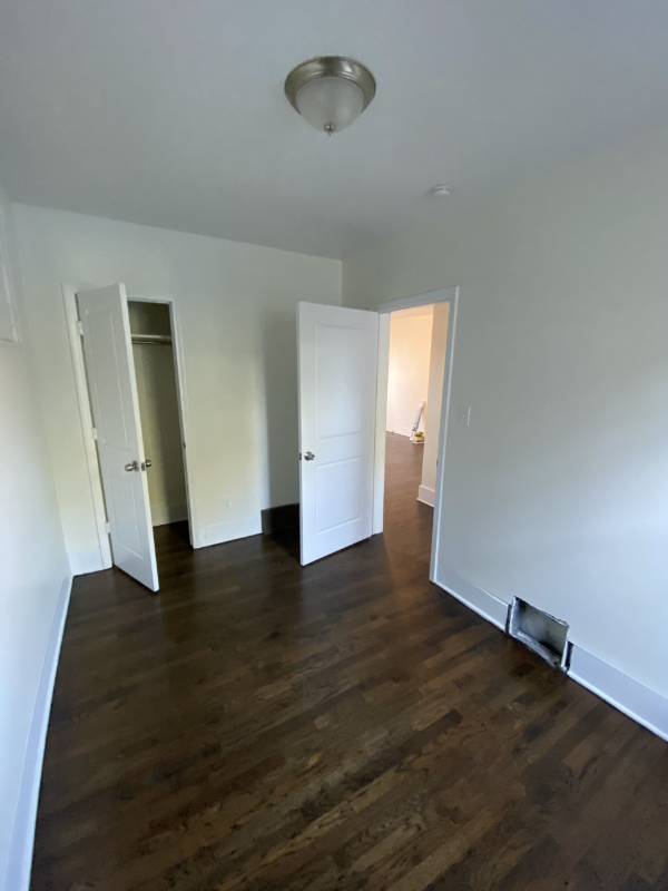 a living room with a hard wood floor and white walls