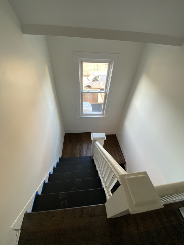 a stairway with a window and a white stair case