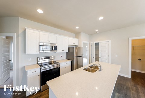 A kitchen with a white counter top and stainless steel appliances.